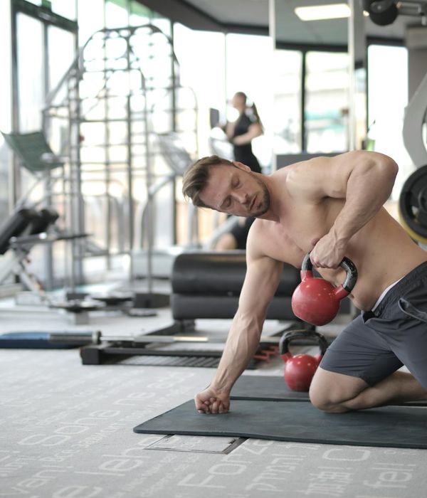 Strong man performing functional strength exercise indoors